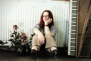 Marta Winnitzki sitzend zwischen Blumen und einem Keyboard