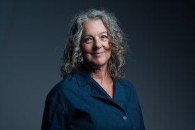 Photo of a smiling woman with long, curly hair
