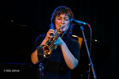 Künstlerin mit Trompete vor einem Mikrofon