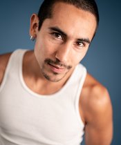 Portraitfoto eines Mannes mit kurzen schwarzen Haaren.