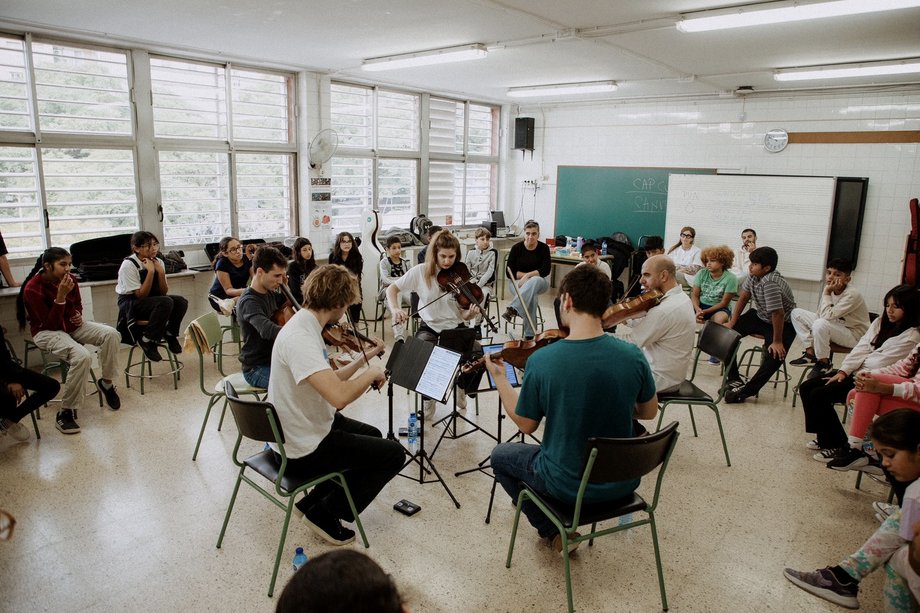 Group with instruments sitting in a circle of chairs