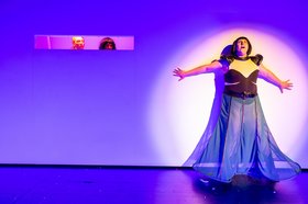 Ein:e Schauspieler:in auf der Theaterbühne