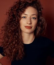 Portraitfoto von einer Frau mit rötlichen Locken