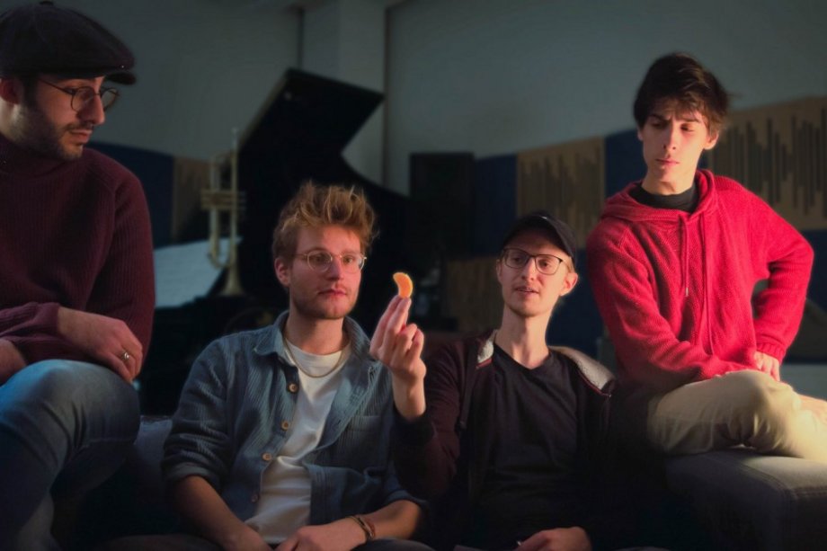 Vier Personen schauen ein Mandarinenstück an.