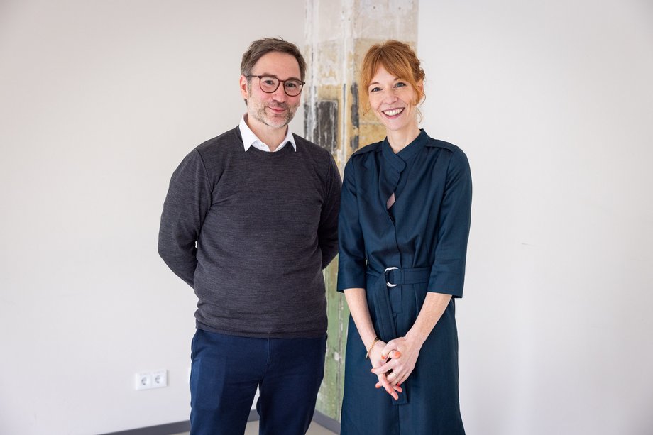 Frau und Mann stehen vor einer Säule