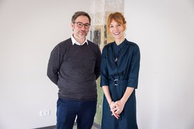 Frau und Mann stehen vor einer Säule