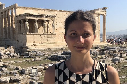 Portrait Roberta Vidic Portrait einer dunkelhaarigen Frau vor einem antiken Bauwerk im Hintergrund