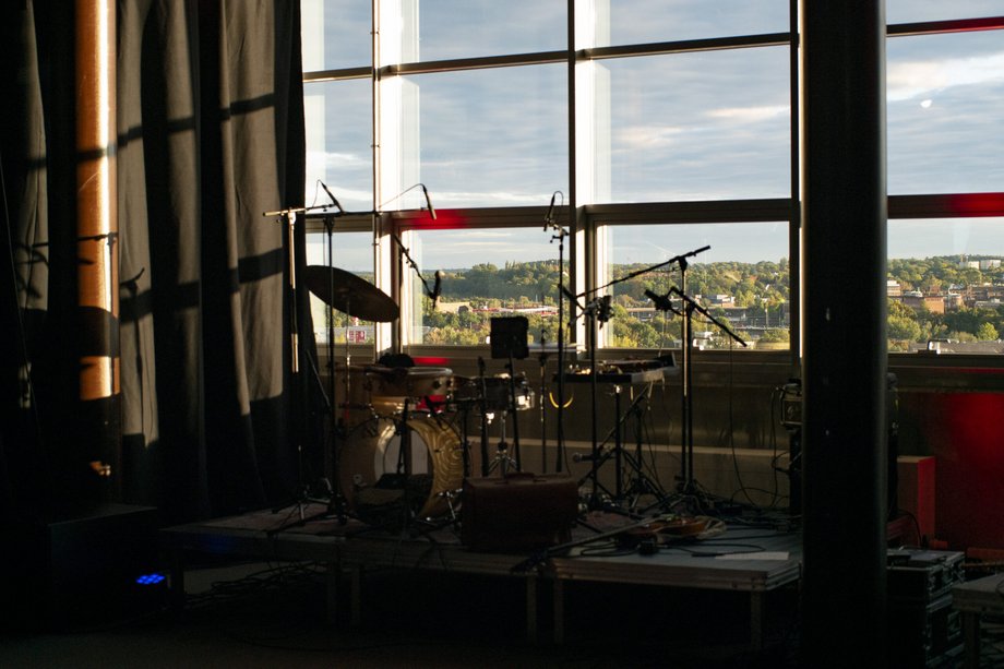 drumset in einem Raum mit Fensterfront und Blick auf Häuser und Bäume von oben