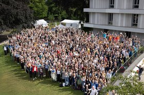 Eine sehr große Gruppe von Menschen auf dem Rasen vor der HfMT