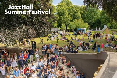 viele Personen auf der Außentribüne der JazzHall und der umliegenden Wiese
