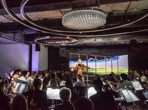 Orchester mit Dirigent und Publikum